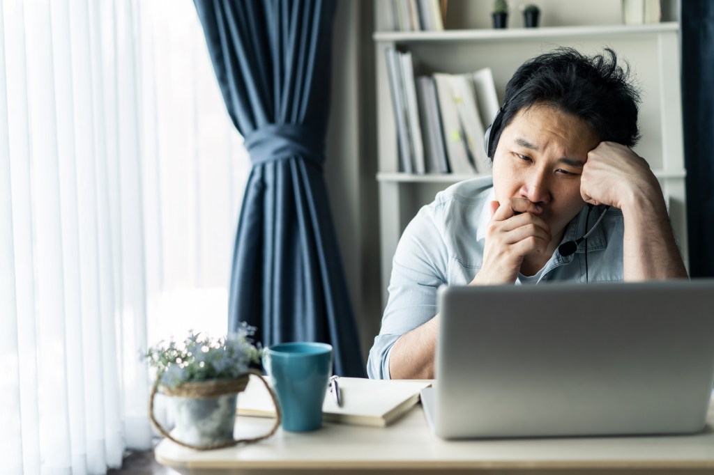 Young Asian businessman working from home, man feeling tired, bored and sleepy sitting at the table.